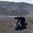 Tina Mariane Krogh Madsen crouching and touching the ground at a volcano crater