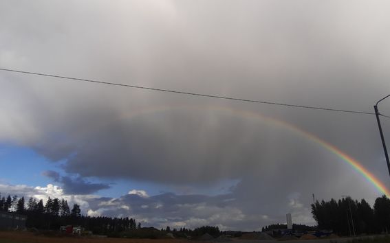 Landscape view with a rainbow and stormy clouds