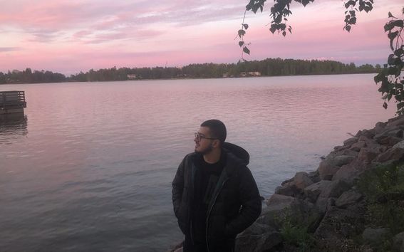 San standing by the water during sunset.