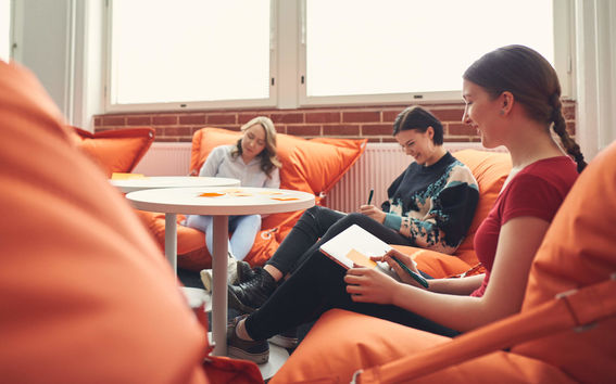 Opiskelijoita istumassa säkkituoleissa