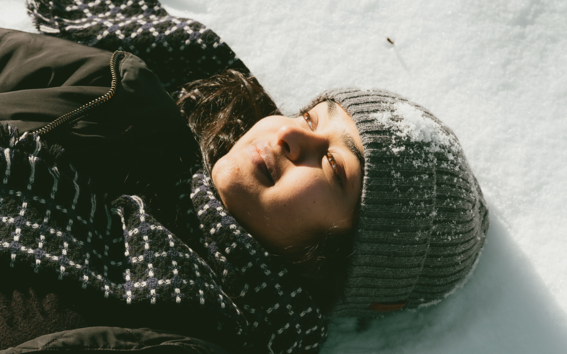 Student laying in the snow