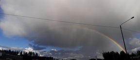 Landscape view with a rainbow and stormy clouds