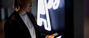 Person scrolling tablet in front of Aalto logo